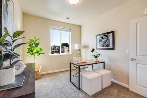 A room with a table, chair, and potted plant.