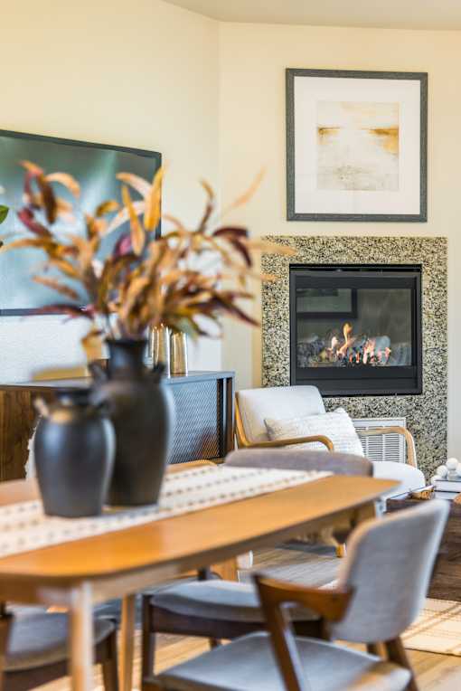 A dining room with a fireplace and a painting on the wall.