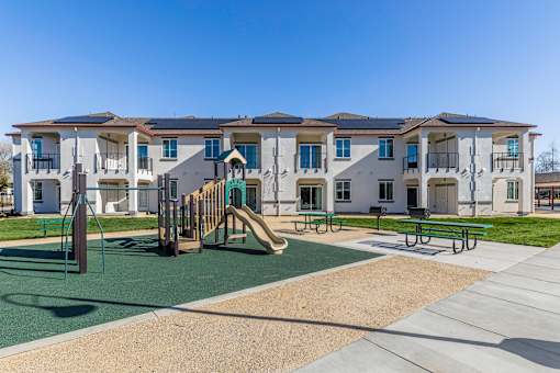 A playground area in front of apartment buildings.