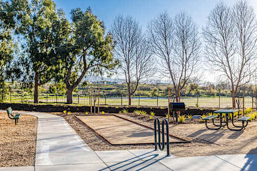 A park with a playground and picnic tables.