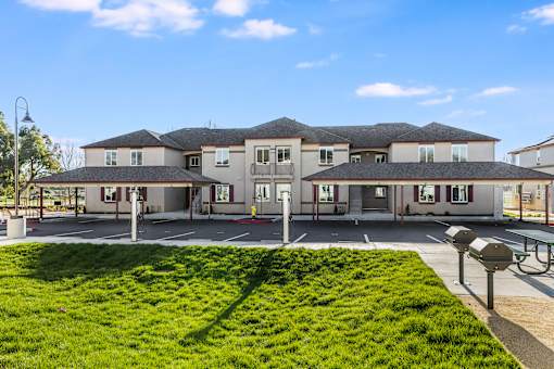 A large building with a green lawn in front.