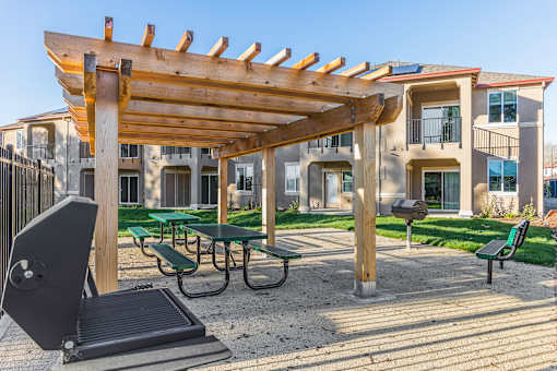 A wooden pergola is over a picnic table.