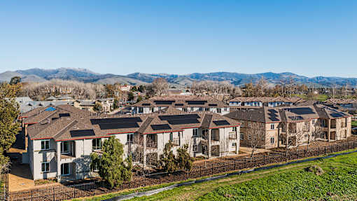 A row of houses with a mountain range in the background.