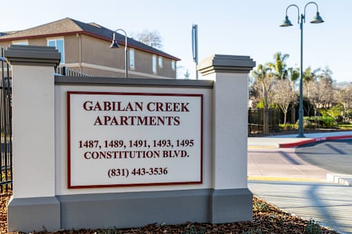 A sign for Gabilan Creek Apartments with a phone number on it.
