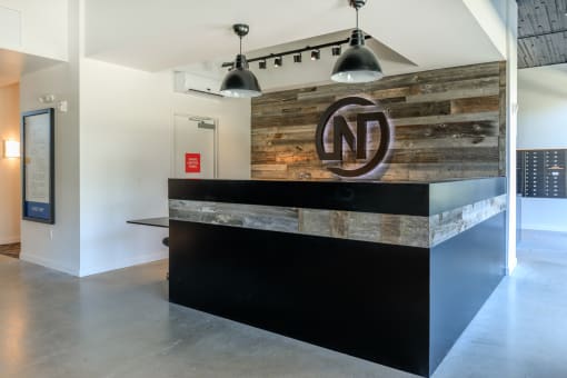 a reception desk with a reclaimed wood wall behind it at Napoleon Apartments, Tacoma, WA 98402