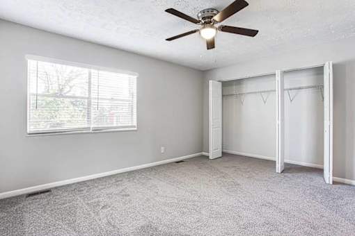 A room with a ceiling fan and a window with blinds at Chelsea Place Apartments, Lithonia, GA