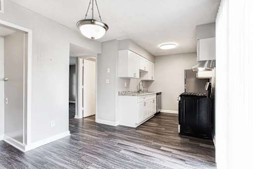 A kitchen with white cabinets and a black refrigerator at Chelsea Place Apartments, Georgia