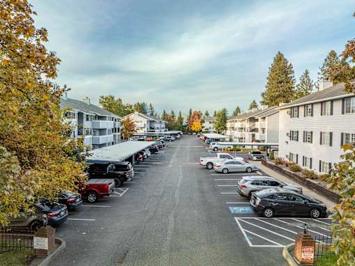 A parking lot with cars and trees in the background.at Ironwood Apartments, Coeur d'Alene, ID