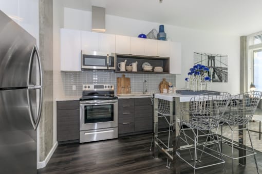 a kitchen with white cabinets and stainless steel appliances at Napoleon Apartments, Tacoma
