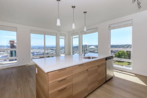 a kitchen with a large center island with a white countertop at Napoleon Apartments, Tacoma, WA
