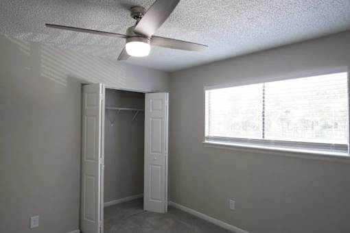 A room with a ceiling fan and a window with blinds at The Madison Apartments and Townhomes, Georgia 30044