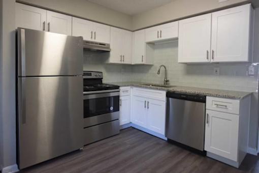A kitchen with a stainless steel refrigerator, oven, and dishwasher at The Madison Apartments and Townhomes, Lawrenceville