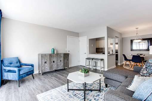 A living room with a blue chair and a grey sofa at Barcelo at East Cobb Apartments, Marietta, Georgia