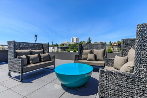 a seating area with couches and a coffee table on a rooftop patio at Napoleon Apartments, Washington, 98402 