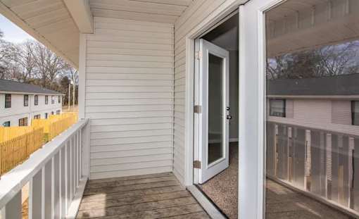 a balcony with a door to a white house at Cleo Apartments, Athens, AL