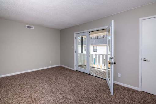 an empty living room with a door to a balcony at Cleo Apartments, Athens, AL