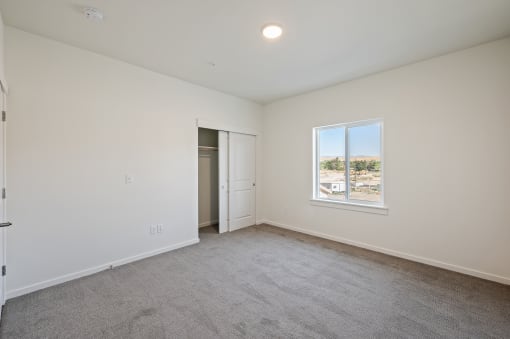 an empty living room with white walls and a window at Gateway Apartments, East Wenatchee , WA