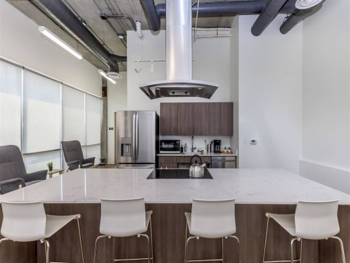 a kitchen with a large island with chairs around it at Jefferson Yards, Tacoma, 98402