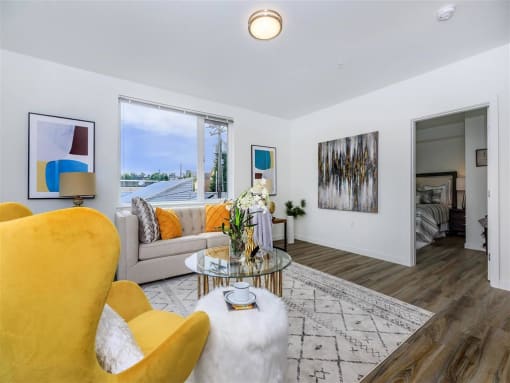 a living room with a couch and a table with a vase of flowers at Jefferson Yards, Tacoma Washington