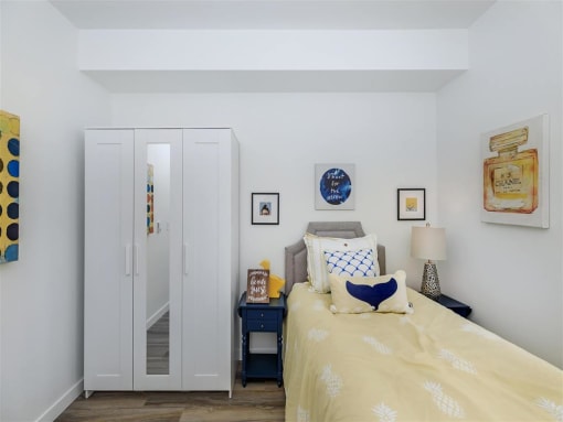 a bedroom with white walls and a yellow bedspread at Jefferson Yards, Tacoma