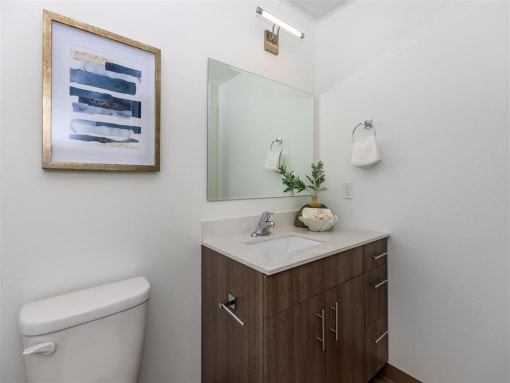 a bathroom with a toilet sink and mirror at Jefferson Yards, Tacoma, WA