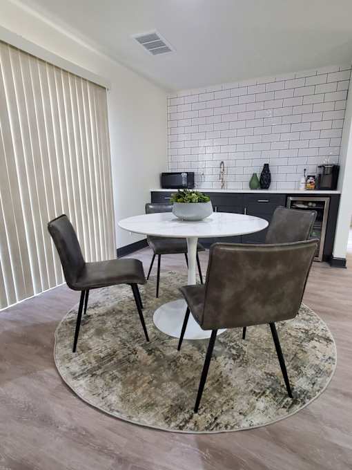 A dining room with a white table and chairs.