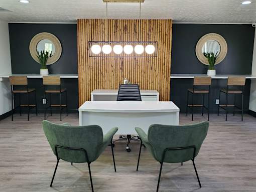 Two green chairs are in front of a white table.
