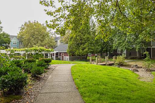 A walkway leads through a grassy area to a building.