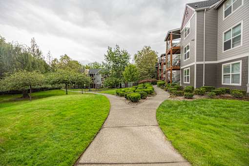 A walkway leads through a grassy area to a building.