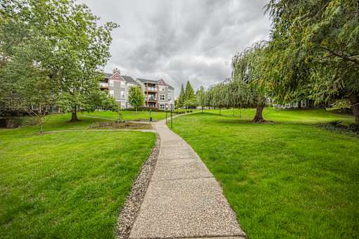 A pathway leads through a grassy area towards a building.
