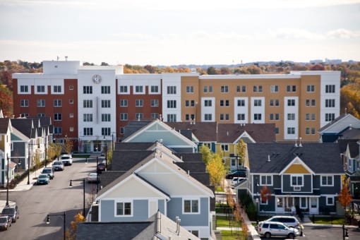 an aerial view of an urban neighbourhood with an apartment building in the background