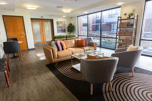 A living room with a couch, chairs, and a rug.