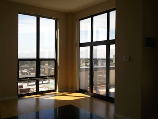 A room with a view of the city through large windows.