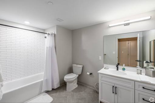 A white bathroom with a toilet, sink, and bathtub.