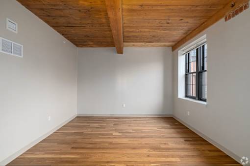A room with wooden floors and a window.
