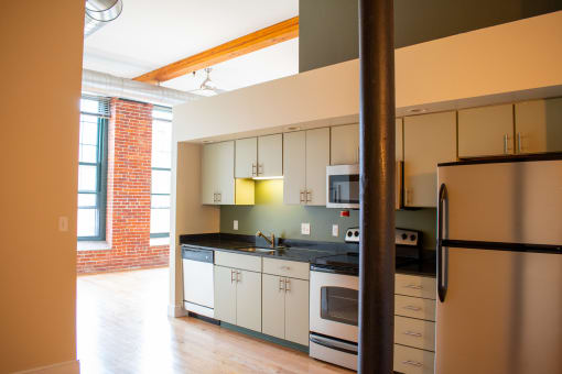a kitchen with white cabinets and a stove and a refrigerator