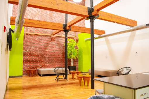 a living room with a table and chairs and a brick wall