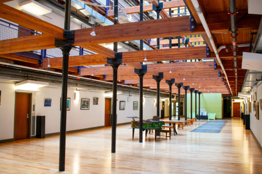 a large room with wooden floors and ceilings and tables and chairs