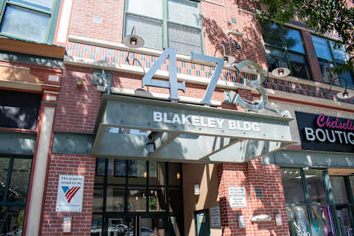 A sign for Blakeley Bldg is displayed above a Chelsleti Boutique.