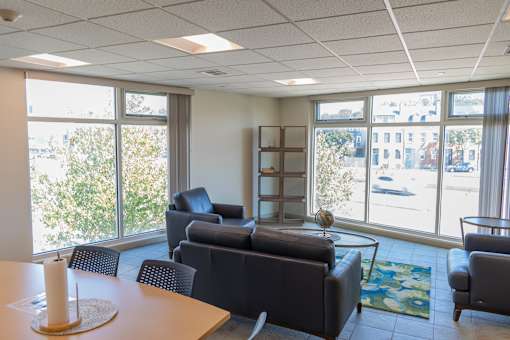 A conference room with a table, chairs, and a view of the street outside.