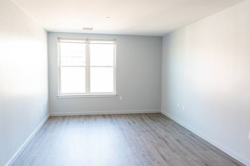 A room with a window and wooden flooring.