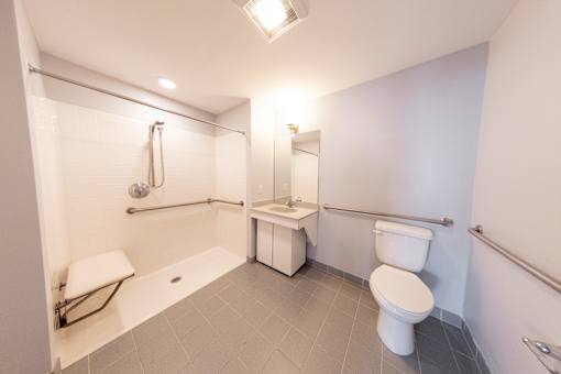A white toilet sits next to a white sink in a small bathroom.
