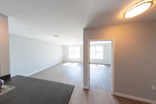 A room with a black mat on the floor and a window letting in light.