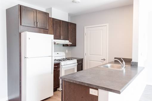 A kitchen with a white refrigerator and a stove top oven.