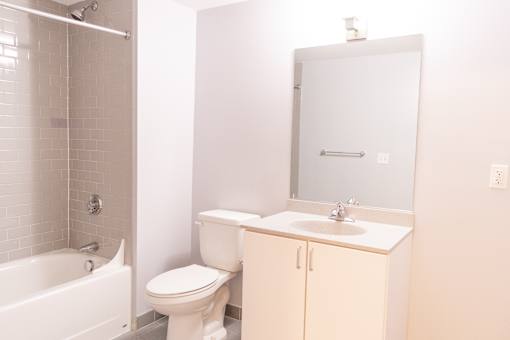 A white bathroom with a toilet, sink, and bathtub.