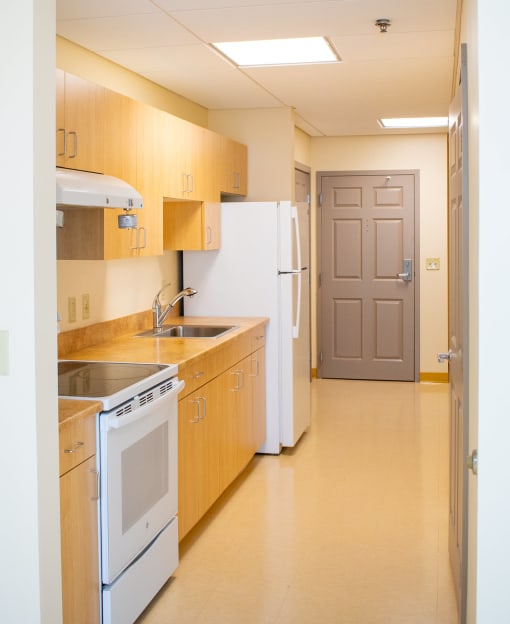 a kitchen with a stove sink and refrigerator and a door