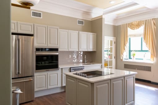 a kitchen with white cabinets and a large island