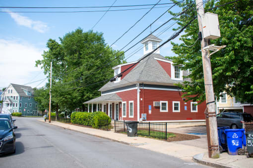 a red building with a grey roof and a white steeple