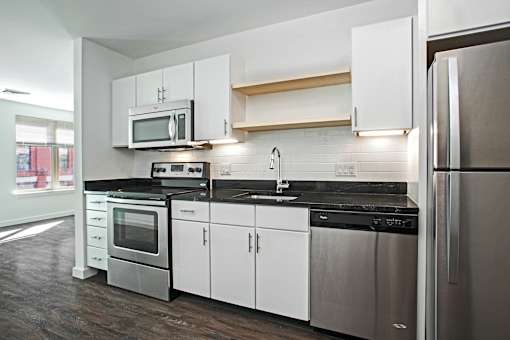 A modern kitchen with stainless steel appliances and white cabinets.