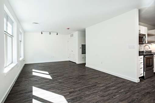 A kitchen with a white wall and a black fridge.